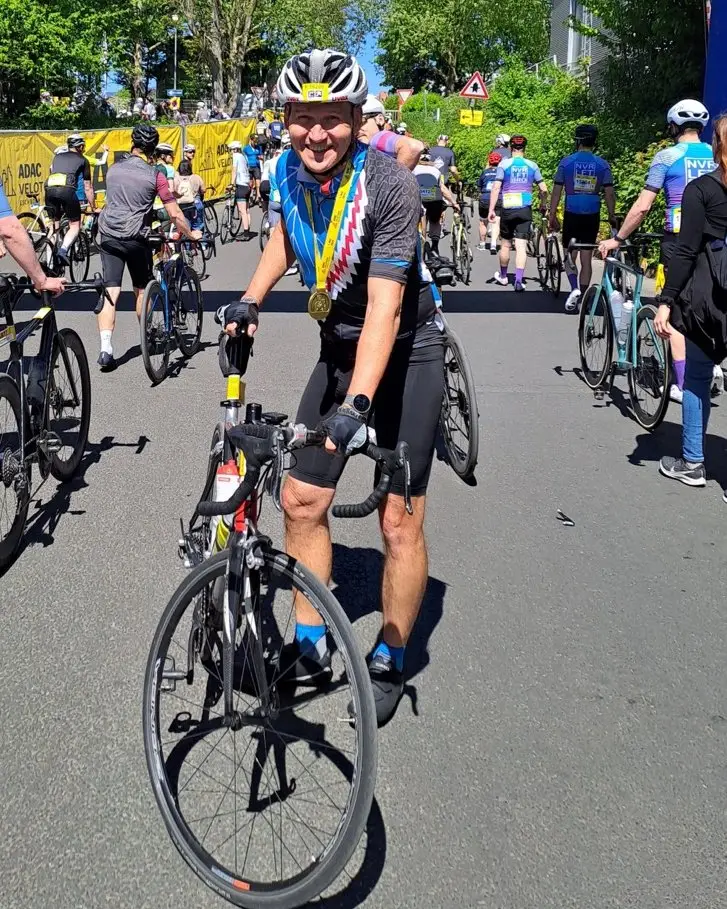 Uwe mit Rennrad und Finisher-Medaille im Ziel des Radklassikers Eschborn-Frankfurt