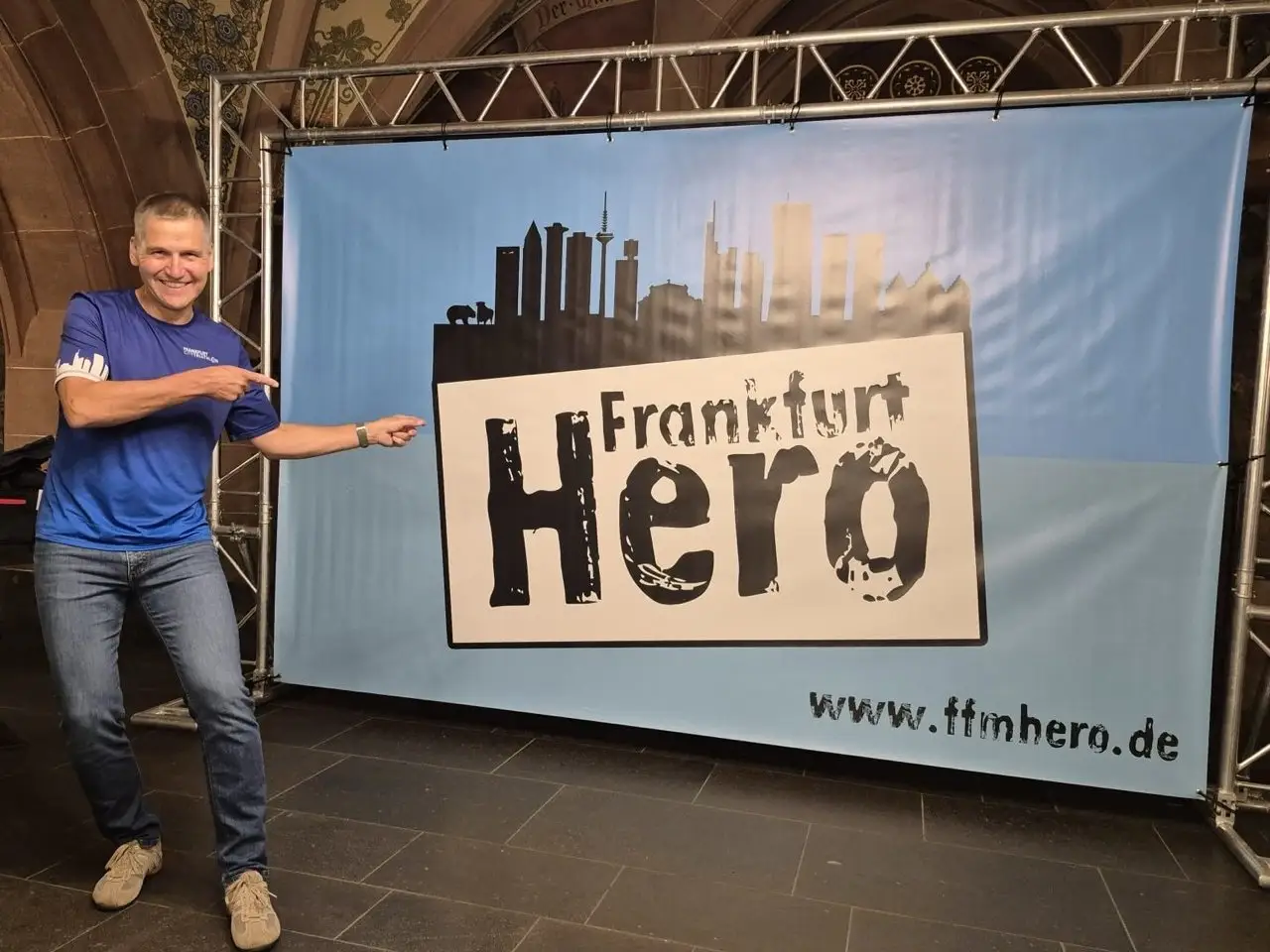 Uwe Martin zeigt auf das Frankfurt-Hero-Banner